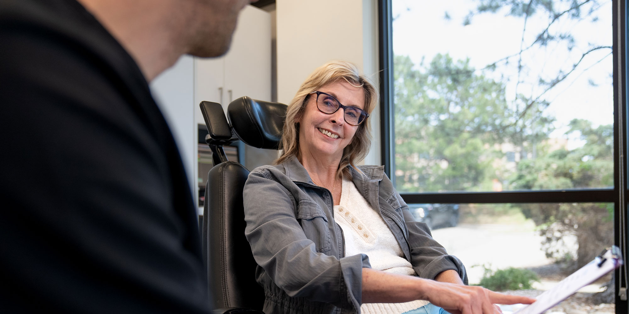 Patient Smiling and pointing at paper work